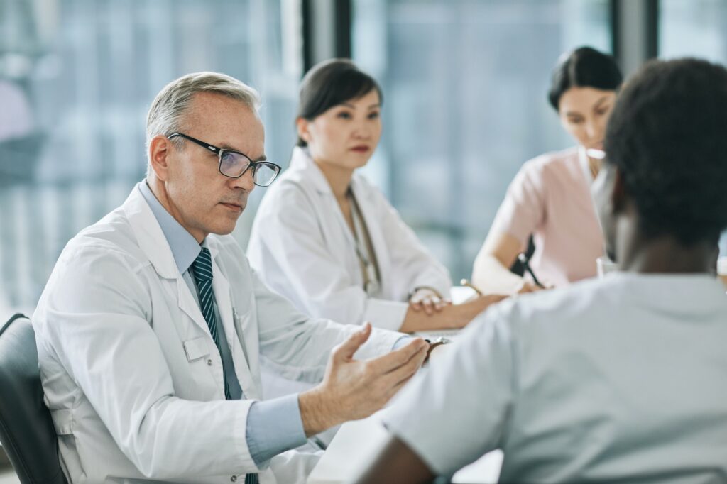 Mature Doctor Talking in Meeting